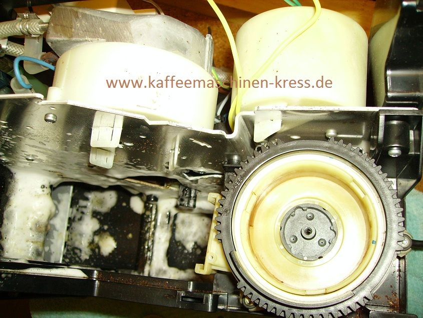 Geöffneter Kaffeevollautomat mit großem Zahnrad und Reinigungsschaum im Innenleben